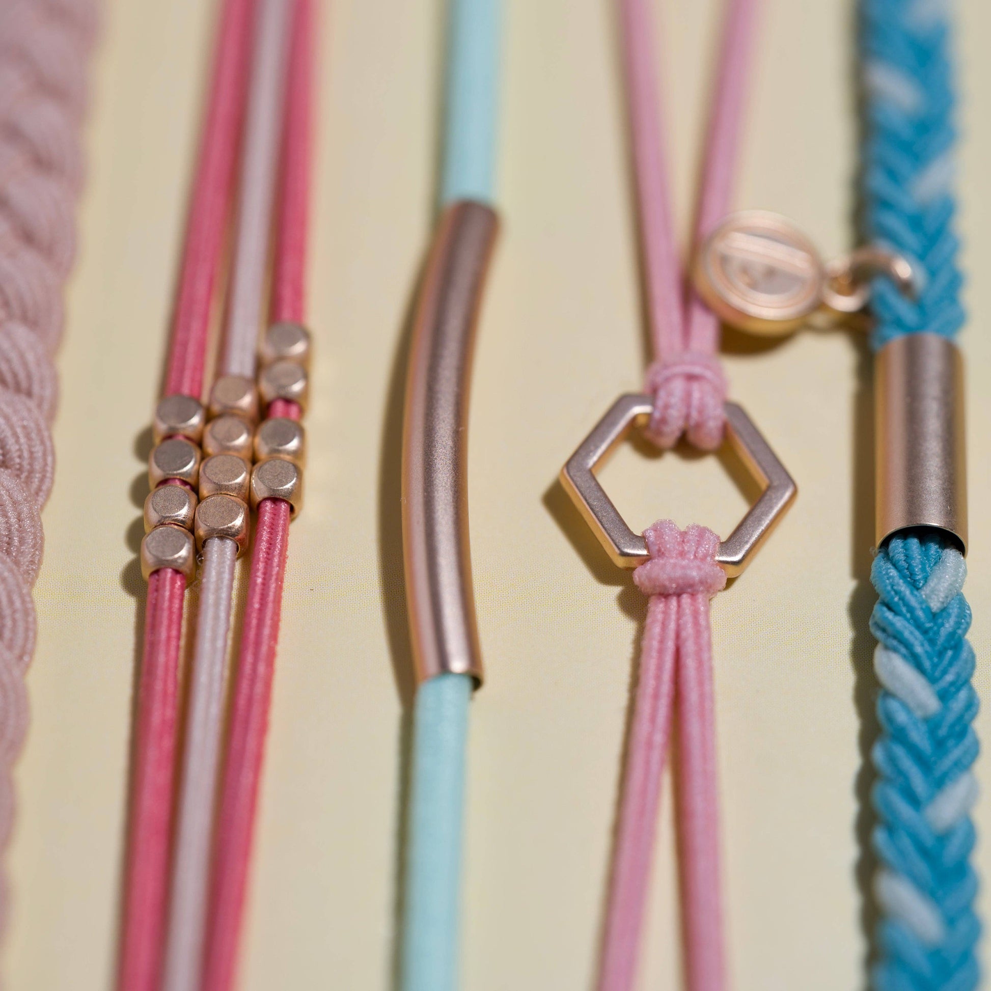 Close-up of colorful bracelets with metal clasps on a beige background. “Live”